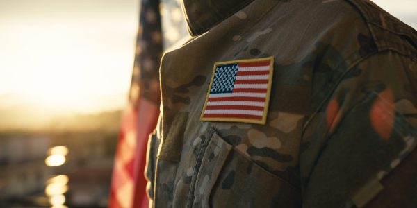 American flag on chest of military man praying for memorial day.