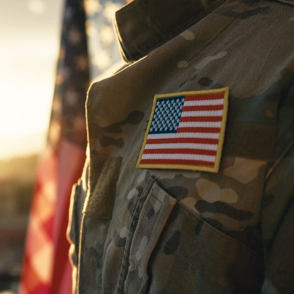 American flag on chest of military man praying for memorial day.